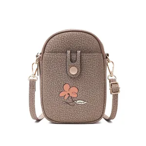 Detailansicht einer strukturierten braunen Mini-Umhängetasche mit Blumenmuster