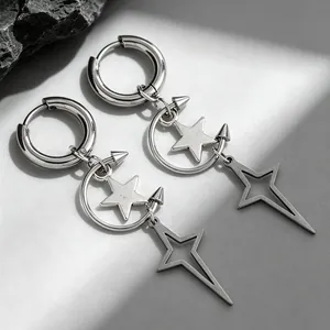 Détail de boucles d'oreilles gothiques argentées avec pendentifs étoile et croissant.