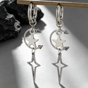 Gros plan de boucles d'oreilles gothiques punk avec lune à pointes et étoiles argentées