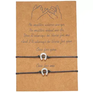 Set of two stainless steel horseshoe charm woven rope bracelets on a brown gift card