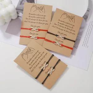 Handmade infinity friendship bracelets with pinky promise message cards on kraft paper