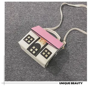 Close-up detail of a novelty house-shaped handbag with pink roof and white walls