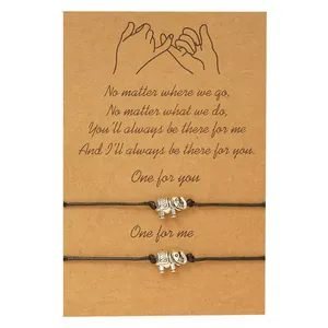 Set of two black wax cord bracelets with elephant charms on friendship message card