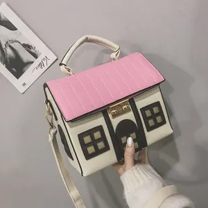 Close-up of a creative house-shaped handbag with pink roof and white walls detail
