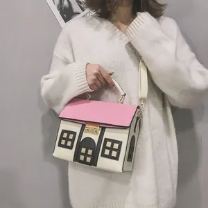 Detail view of a creative house-shaped crossbody bag with pink roof and white walls