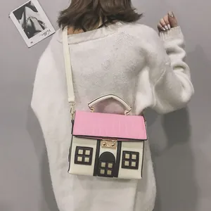 Back view of a woman wearing a creative house-shaped crossbody bag with a pink roof.