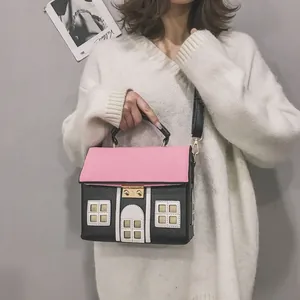 Unique house-shaped crossbody bag with pink roof and cute window details on model