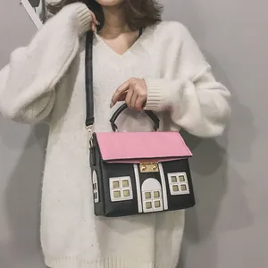 Close-up of creative house-shaped crossbody bag with pink roof and black walls