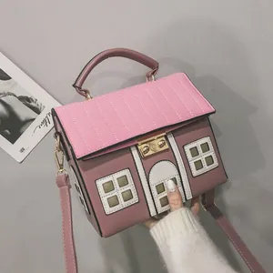 Detailed view of a unique house-shaped crossbody bag featuring pink and mauve panels