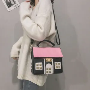 Detailed view of creative house-shaped crossbody bag with pink roof and black walls