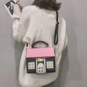 Close-up of a creative house-shaped crossbody bag with pink and black color-blocking