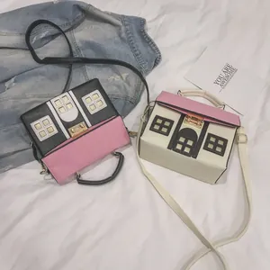 Two creative house-shaped crossbody handbags in black and white with pink accents.