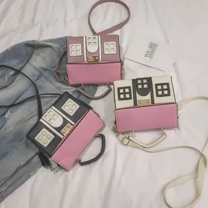 Close-up of creative house-shaped handbags in black, pink, and cream color options