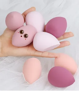 A collection of ultra-soft teardrop makeup sponges in various pink shades on delicate mesh fabric.