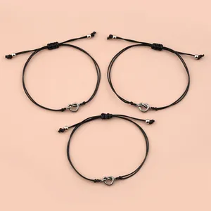 Three-piece set of black wax cord bracelets featuring adjustable sliding knot heart pendants