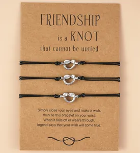 Detail of three black friendship knot bracelets on a brown gift card background