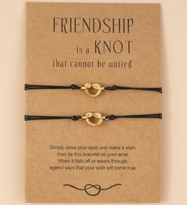 Macro view of two friendship knot bracelets with wish card for best friends gift