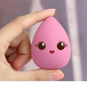 Close-up macro view of a soft pink water-drop makeup sponge with a cute cartoon face