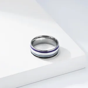 Makro-Detail eines minimalistischen Edelstahlrings mit buntem Emaille-Streifenmuster
