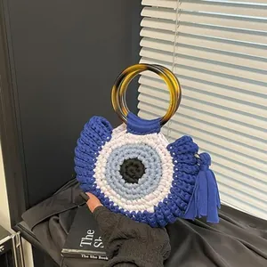 Detailansicht der gewebten Evil Eye Handtasche mit blauem Quasten und Acrylgriff
