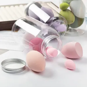 Detailed view of multi-sized pink makeup sponges spilling from a clear storage jar.