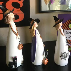 Detailset aus drei weißen Halloween-Hexenfiguren mit Kürbis- und Katzenakzenten