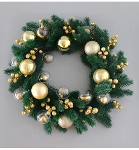 Detailed close-up of a green pine Christmas wreath with elegant golden ornaments