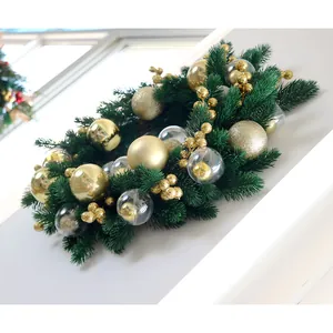 Luxurious Christmas wreath with pine needles, gold baubles, and clear ornaments on a wall