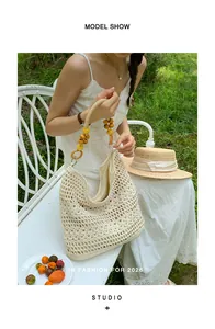 Beige hand-crocheted woven tote bag with wooden beads shown in an outdoor park