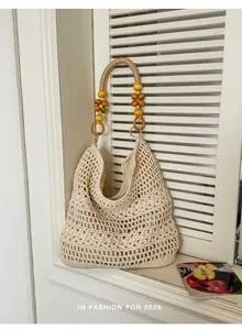 Handmade crochet beach bag with decorative wooden bead handle and hollow-out floral pattern