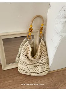 Detail view of handmade crochet hobo bag featuring ornate wooden bead handle for holidays