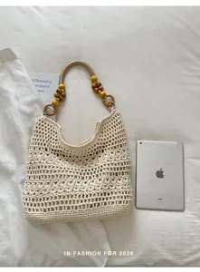 Hand-knitted crochet beach tote bag shown next to a tablet for size reference