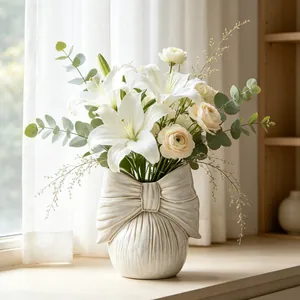 Creamy white ceramic ribbon bow vase with elegant white lilies for home decoration