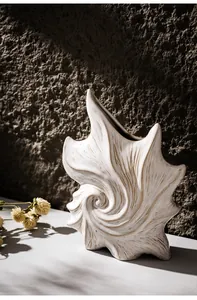 Nahaufnahme einer künstlerischen weißen Muschelvase aus Keramik mit eleganter Spirale.