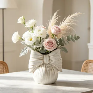 Detailed view of an elegant cream ceramic bow vase with a beautiful flower bouquet.