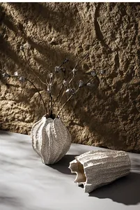 Close-up of textured Nordic ceramic vases with organic fluted edges in warm light