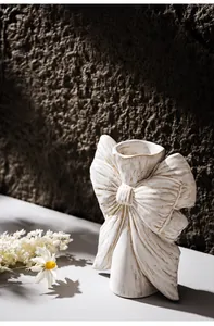 Close-up detail of white bow-knot ceramic vase with an elegant vintage textured finish
