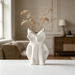 Elegante vaso a forma di gufo in ceramica bianca con fiori secchi in un interno