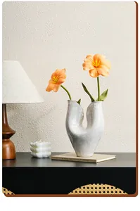 Detail view of modern white ceramic vase with artistic U-shape in a cozy home setting
