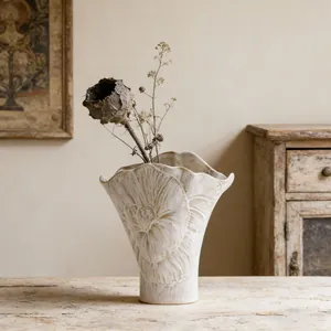 Detalle de jarrón de cerámica artístico francés con relieve floral y diseño ondulado