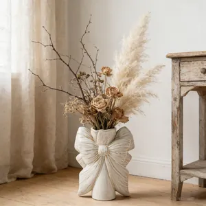 Vase en céramique blanche en forme de nœud avec fleurs séchées décor d'intérieur