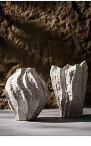 Macro view of white organic textured ceramic vases in a rustic stone setting decor