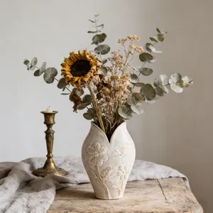 Detail van wabi-sabi keramische vaas met elegante bloempatronen in reliëf.
