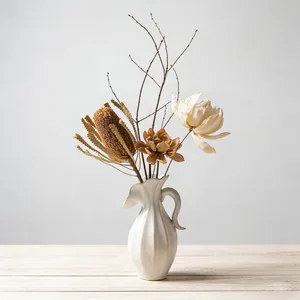Elegante Noordse crème keramische vaas met droogbloemen op houten tafel