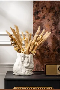 Elegant white ceramic tote bag vase with bow detail and dried pampas grass arrangement