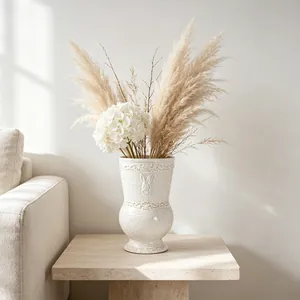 Close-up view of a French vintage white ceramic vase with rabbit relief in a living room.