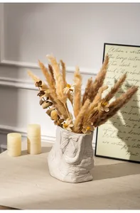 French style ceramic bag vase with dried pampas grass on a textured table
