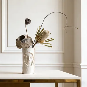 Moderne Noordse artistieke keramische vaas met gezicht en elegante droogbloemen