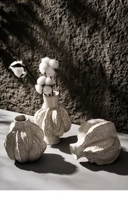 Detailed view of organic textured white ceramic vases with rustic wall background