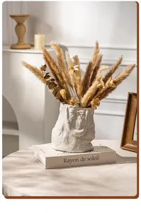 Close-up of a white textured ceramic vase in a French bag shape with dried flowers